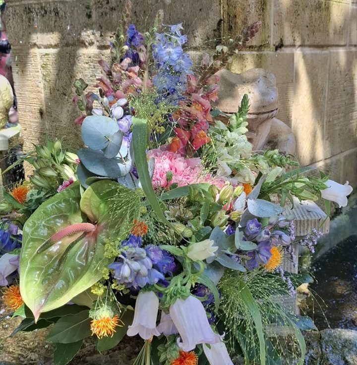 Bunte Blumenarrangement mit verschiedenen Pflanzen und Farben, dekorativ angeordnet.